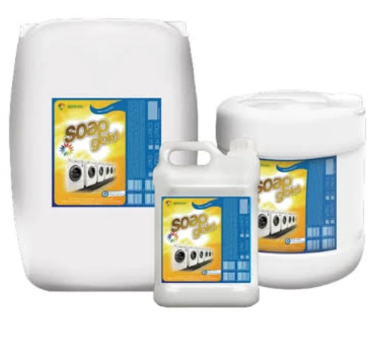 Três recipientes plásticos brancos de tamanhos variados, cada um com rótulo amarelo e azul identificado como “Soap Gold”. Os rótulos exibem imagens de máquinas de lavar, reforçando aplicação em lavanderias ou ambientes de grande escala. Embalagens de 5 litros ou mais indicam uso institucional e comercial, voltado à limpeza em larga escala.