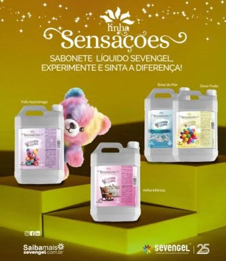 Quatro frascos plásticos da Linha Sensações da Sevengel exibem fragrâncias “Folha Aromática”, “Brisa do Mar”, “Gotas Frutais” e “Veludo Intenso”. Entre eles, urso de pelúcia colorido chama atenção. Texto promocional destaca “Experimente e sinta a diferença!”, junto ao logotipo da marca e menção aos 25 anos de atuação.